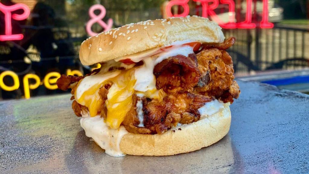 Chicken Bacon Ranch Sandwich · Crispy fried chicken breast topped with a melted mix of mozzarella and cheddar cheese, crispy bacon, and ranch dressing. Served on our brioche bun with fries, Lettuce, Onion, Tomato, Aioli all served on the side.