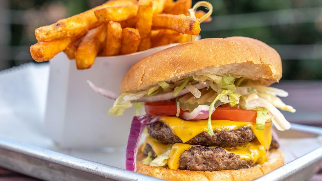 Classic American Burger · Two quarter pound flat top grilled patties. Includes American cheese, lettuce, tomato, onion, pickle, and Frey burger sauce. Served with fries.