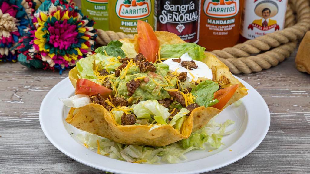 Taco Salad · Hard shell flour tortilla filled with lettuce, tomatoes, cheese, and your choice of dressing. Topped with your choice of meat, sour cream, and guacamole.