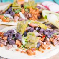 Tacos Rancheros · Two carne asada tacos mixed with homemade chorizo, black beans, nopales, onions and cilantro.
