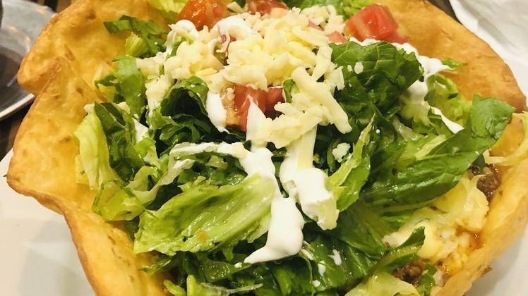 Taco Salad · Crispy flour tortilla shell filled with ground beef or chicken tinga, beans, lettuce, tomatoes, cheese and sour cream.