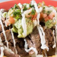 Steak & Fries · Delicious steak strips served on a bed of French fries topped with cheese, sour cream, pico ...