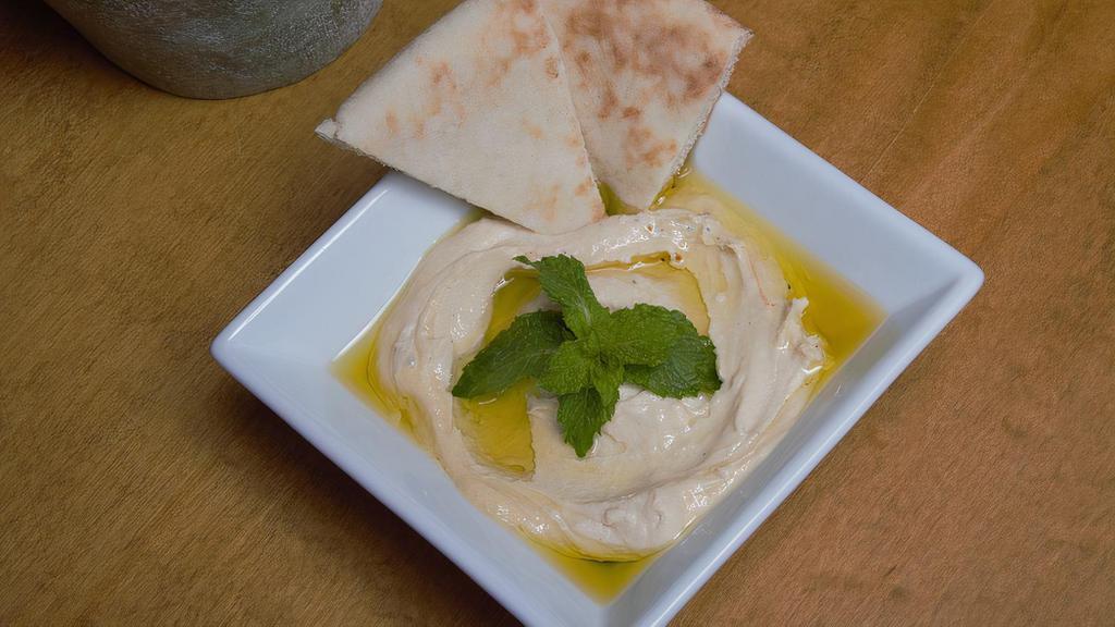 Hummus · A serving of our famous middle eastern hummus! Hummus is made of smashed chick peas, tahini, olive oil, lemon juice! Served with a piece of pita bread!