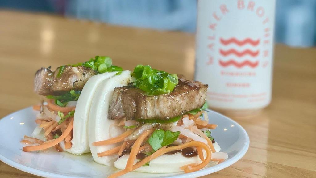 Bao Buns W/ Tofu · Two steamed rolls with pickled daikon and carrots, jalapeño, fresh cilantro, scallion oil, and hoisin sauce.