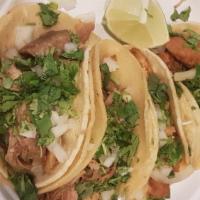 Tacos De Pollo Asado · Three grilled chicken breast tacos with sauteed onions and cilantro, topped with cabbage and...