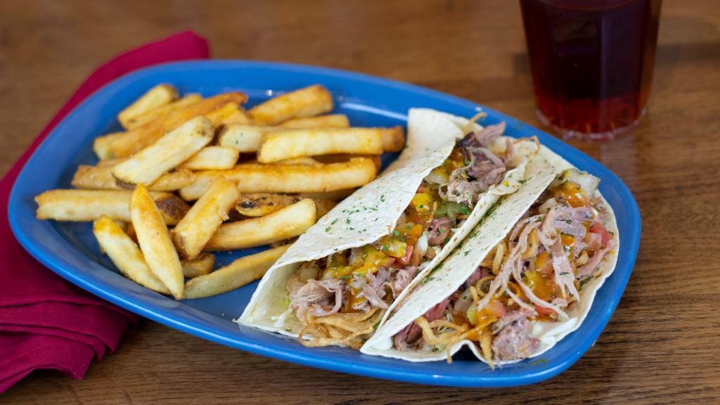 Pulled Pork Tacos · Two soft flour tortillas filled with tender pulled pork and Carolina Gold BBQ sauce, green cabbage, housemade Pico, and crispy onion straws.