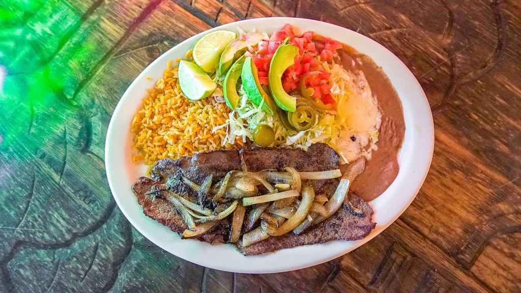 Carne Asada · Beef steak served with rice, beans, tomatoes, onions, lettuce, avocado and jalapeños.