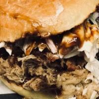 Pork Sandwich · House-smoked pulled pork served with slaw on a brioche bun. Choice of ancho bbq (mustard bas...