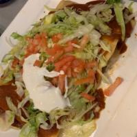 Enchiladas Con Crema · Two chicken enchiladas topped with our special sour cream cheese sauce with rice and beans.