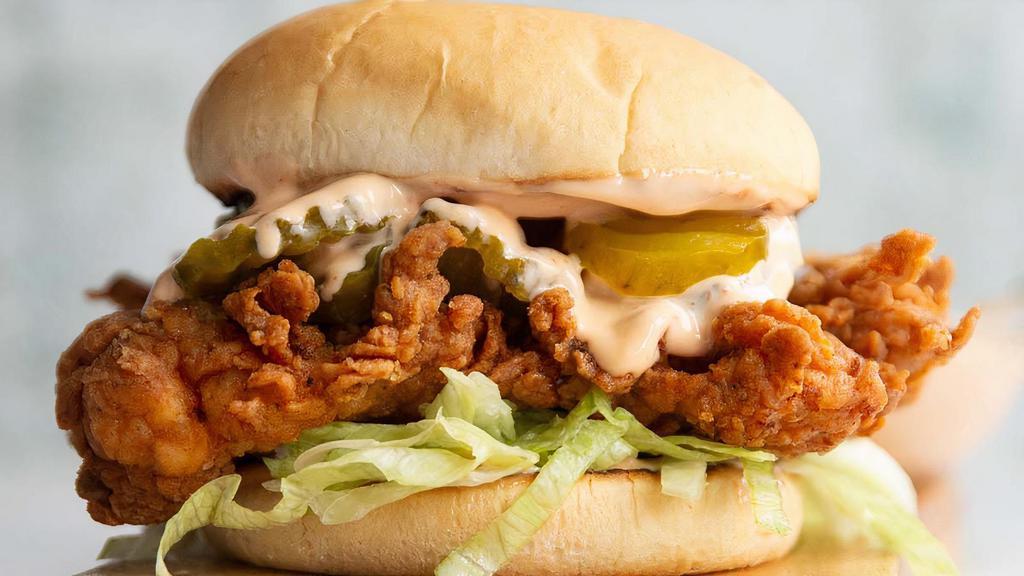 Fried Chicken Sandwich · Crispy fried chicken breast with mayo and pickles on a toasted bun with a side of fries.