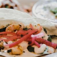 Lemon Grilled Shrimp Tacos · Lemon-grilled shrimp, stuffed with guacamole, pickled onion, fresh greens, tomato & mixed ch...