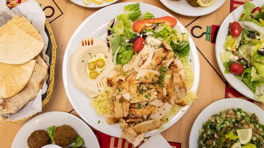 Chicken Shawarma (Plate) · Shave cut marinated chicken + garlic aioli. Plate includes rice, hummus, salad, and pita.