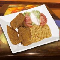 Milanesa A De Carne · Breaded beef served with Spanish rice, salad, and tortillas.