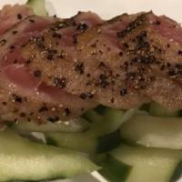 Black Pepper Tuna · Cucumber salad with peppered tuna on top.