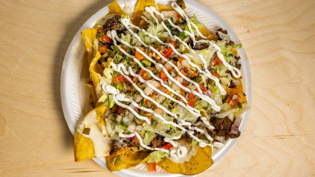 Nachos Supreme · Nachos loaded with your choice of meat, cheese dip, pico de gallo, lettuce, and sour cream.