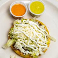 Sopes · Topped with beans, your choice of meat, lettuce, cheese, and sour cream.
