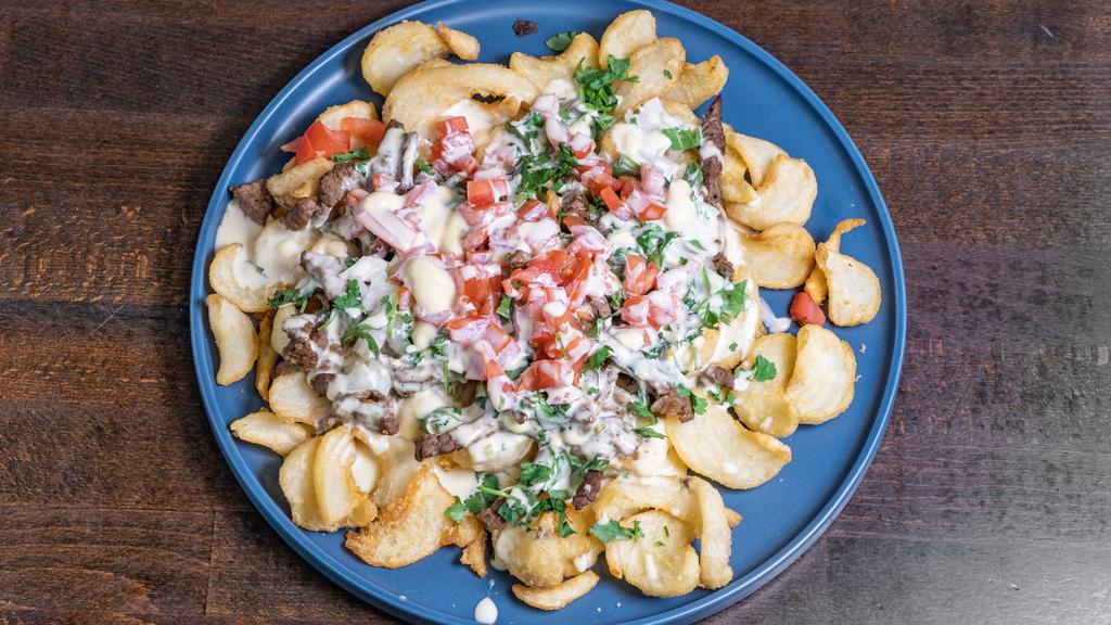 Carne Asada Fries · Steak, onion, cilantro and queso on a bed of fries