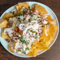 Nachos · Corn chips, meat, lettuce, tomato, onion, cilantro, jalapeños, covered in queso dip