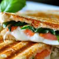 Caprese · Pesto, tomato, spinach, mozzarella, and honey balsamic reduction served on sourdough bread.