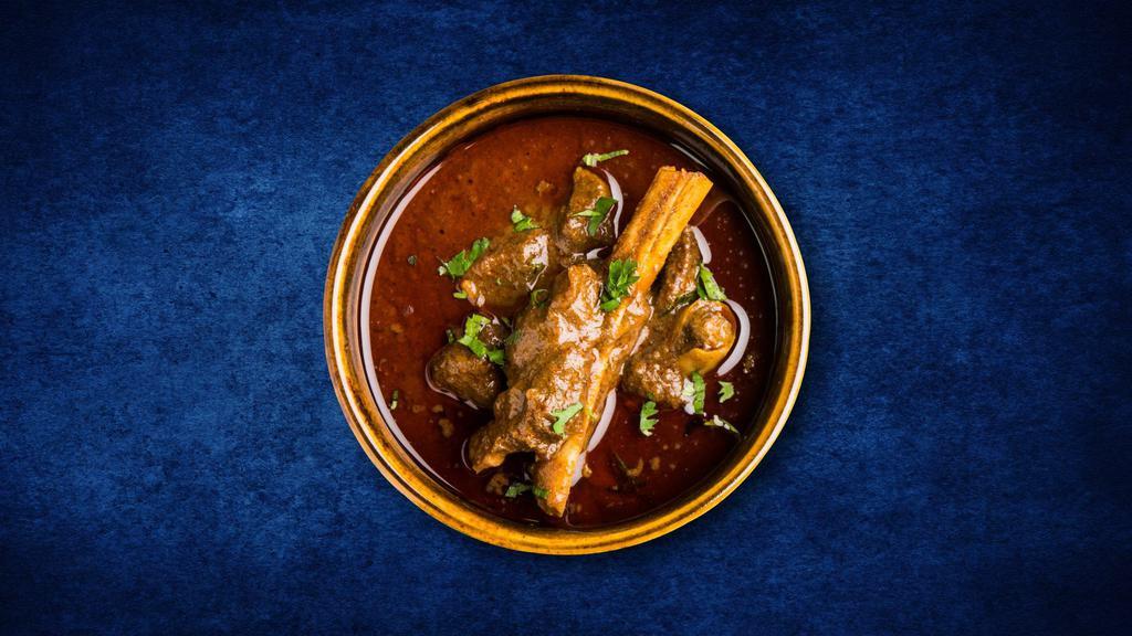 Just Goat Curry · Succulent goat meat slow cooked in a classic brown curry, served with a side of our aromatic basmati rice