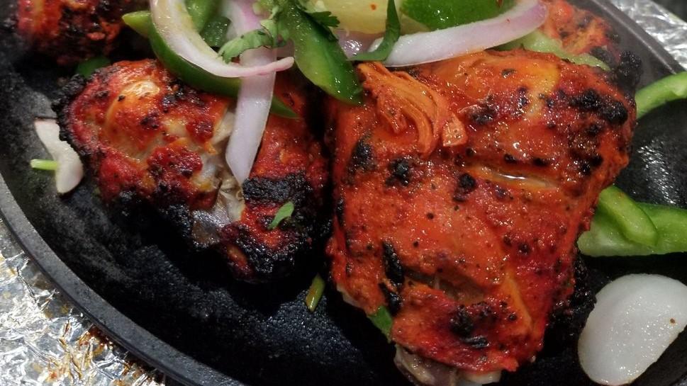 Tandoori Chicken · Tandoori chicken is chicken dish prepared by roasting chicken marinated in yogurt and spices in a tandoor, a cylindrical clay oven.