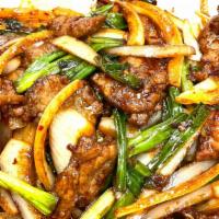 Spicy Mongolian Beef · Wok-fried strip beef with onion, scallions and chili on a bed of crispy rice noodles.