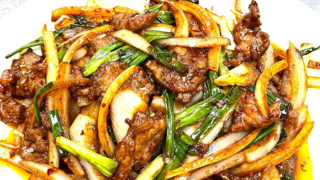 Mongolian Beef · Wok-fried sliced beef with onion, and scallions, served on a bed of snow-white crispy rice noodles.