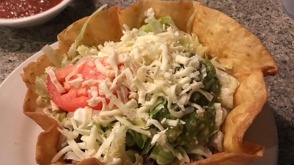 Taco Salad · Crispy flour tortilla shell with choice of ground beef or chicken, beans, lettuce, tomatoes, cheese, sour cream, and guacamole.
