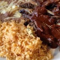 Chile Colorado · Sizzling strips of steak with mole sauce, grilled mushrooms, and onions. Served with rice, b...