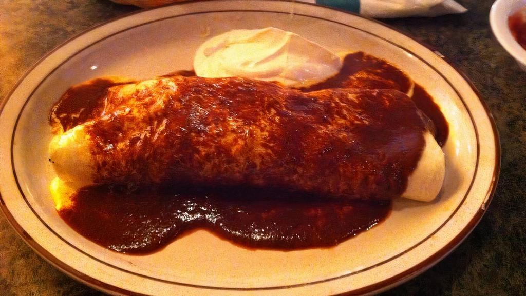 Burrito California · Extra-large burrito stuffed with beans, cheese, sour cream, grilled onions, and choice of chicken or beef. Topped with mole sauce and nacho cheese.