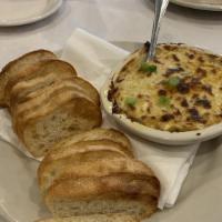 Hot Blue Crab Dip · fresh Louisiana crabmeat baked in a decadent parmesan cream served with warm crostinis.