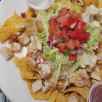Nancy'S Kickass Nachos · Fresh tortilla chips with choice of grilled chicken, ground beef, or chili. Topped with home...