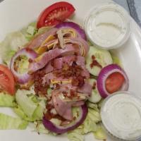 Loaded Chef Salad · Iceberg topped with sliced ham, turkey, swiss and american cheese, cucumbers, tomatoes, red ...
