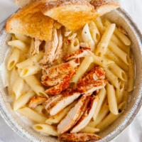 Blackened Chicken Alfredo · Tender grilled chicken on a bed of penne pasta with our homemade cajun cream sauce served wi...
