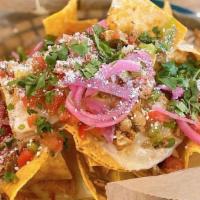 Nachos Rocas · Fresh tortilla chips piled high with queso, red beans, pico de gallo, pickled onions and cil...