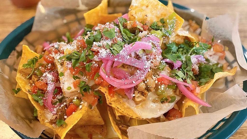 Nachos Rocas · Fresh tortilla chips piled high with queso, red beans, pico de gallo, pickled onions and cilantro.  Vegetarian and gluten free