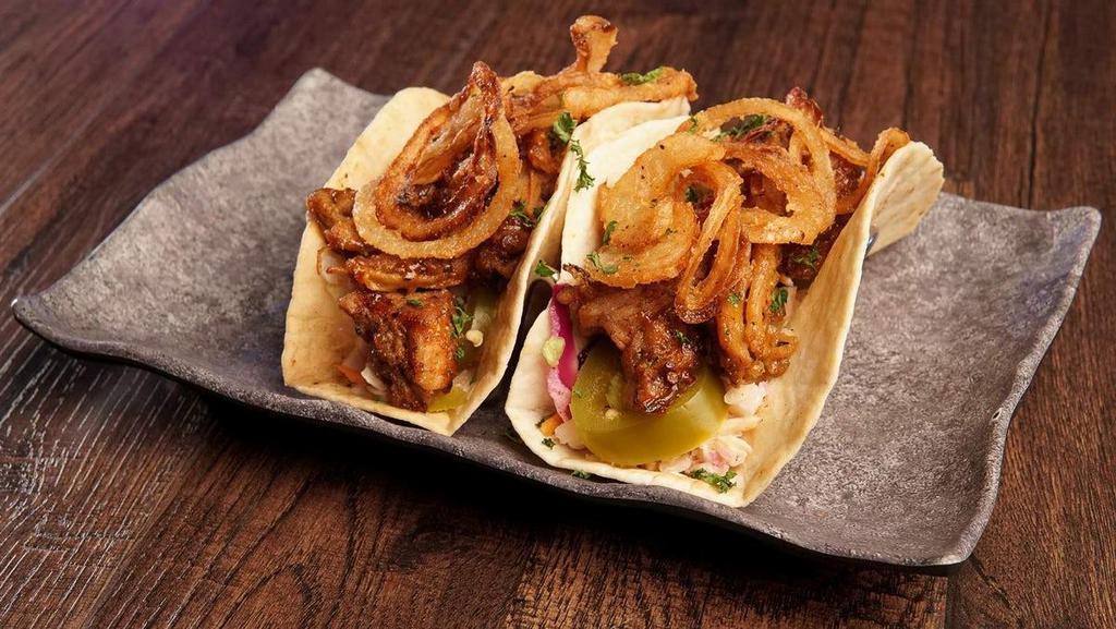 Carolina Pulled Pork Tacos · roasted pulled pork tossed in carolina gold. sauce, on top of coleslaw with thin fried. onion straws & jalapeños