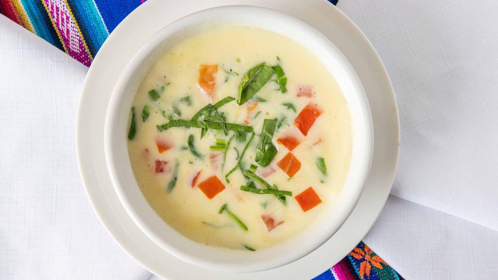 Queso Blanco · White cheese dip with diced tomatoes and fresh spinach.