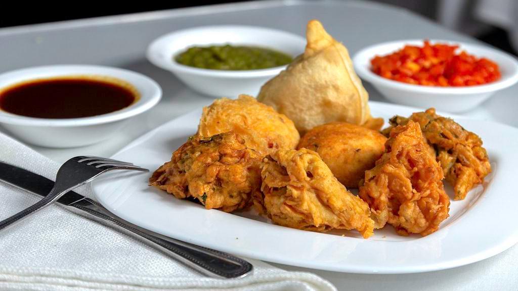 Vegetarian Appetizer Platter · Assortment of veg samosa, veg pakora, onion bhajhi, aloo tikki and paneer pakora.