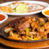 Fajitas Texanas · Marinated strips of chicken, steak, and shrimp with peppers, onions and tomatoes.