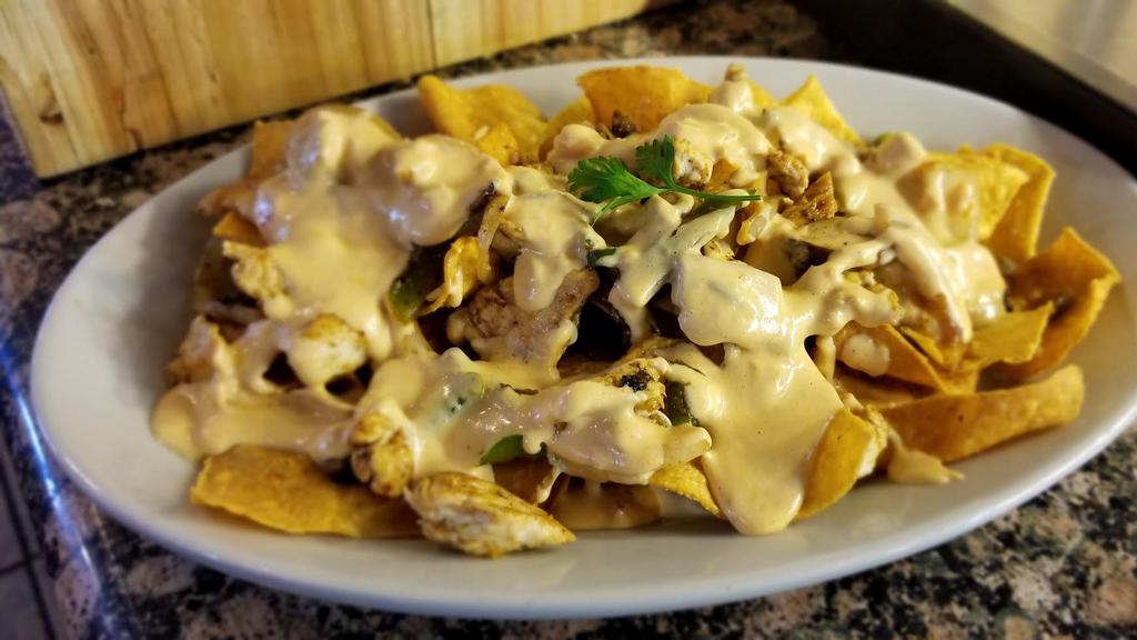 Fajita Nachos · Tortilla chips piled high with onions, bell peppers, mushrooms, and your choice of fajita chicken or steak; smothered in pop's cheese dip or Blanco dip. Served with sour cream and our homemade salsa.