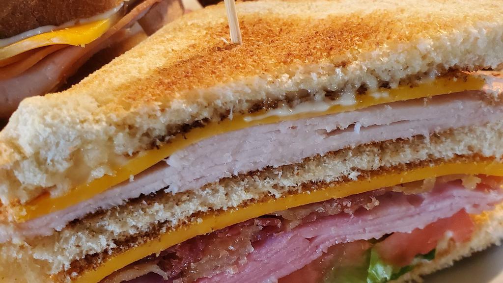 Club · Your traditional club! Sliced turkey & ham served on your choice of toasted white or wheat bread with crisp bacon, cheddar cheese, lettuce, tomato & mayo