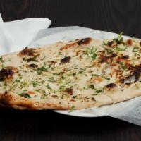 Garlic Naan · Leavened bread sprinkled with crushed garlic, baked in the tandoor.