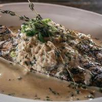 Redfish Acadiana · Grilled redfish topped with a lemon butter sauce served with one side.