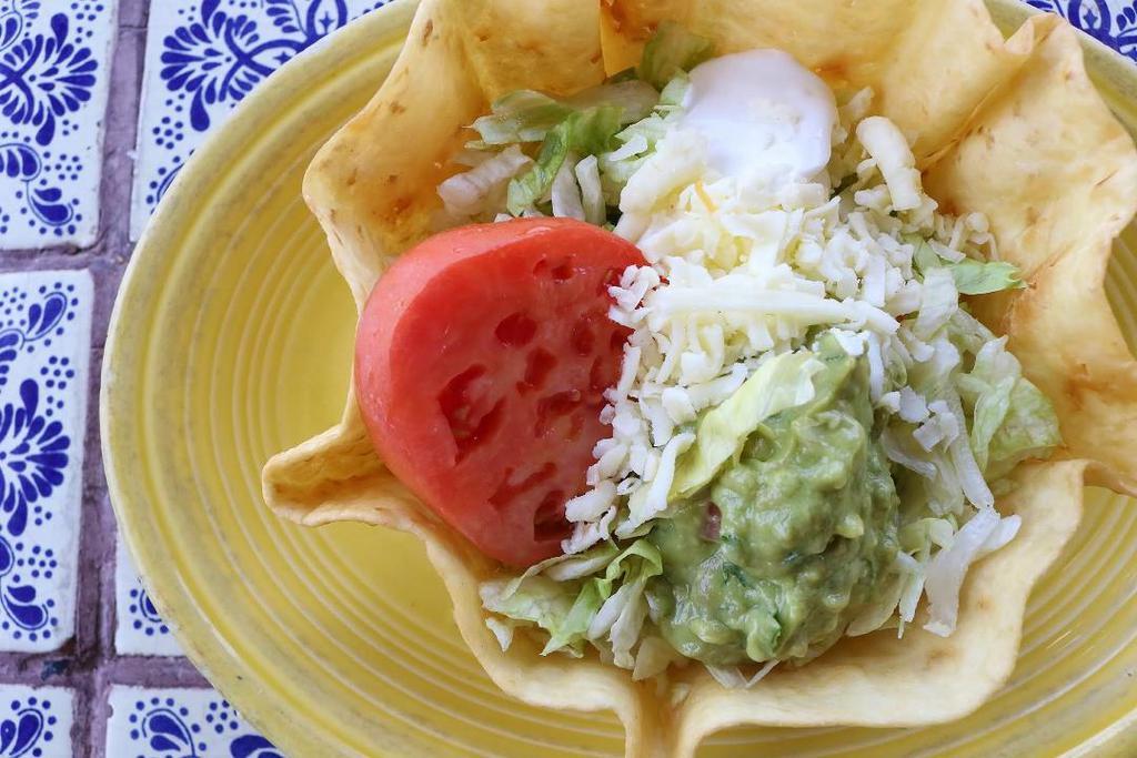 Lunch Taco Salad · Crispy taco bowl shell filled with your choice of juicy shredded chicken, fresh ground beef, or chunk beef, topped with cheese, lettuce, guacamole, sour cream, and tomatoes.