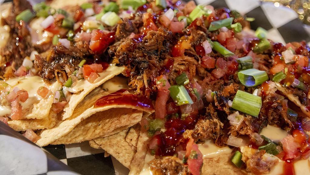 Bbq Pork Nachos · Southern pulled pork topped with homemade queso, pico de gallo and sour cream, over crispy house made tortilla chips.