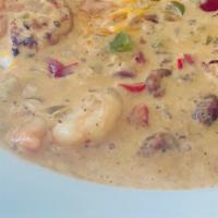 Shrimp & Grits · Gulf shrimp sautéed with bell peppers and onion in a spicy sauce over creamy smoked Gouda gr...