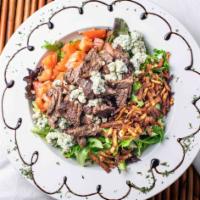 Grilled Steak Salad · Marinated flank steak fire-grilled to order and perched atop field greens, tomato, bleu chee...