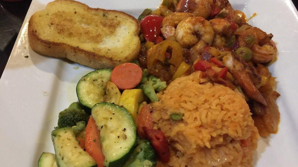 Shrimp A La Veracruzana · Tasty shrimp grilled and covered with a spicy Veracruz sauce. Served on a bed of Mexican rice with steamed vegetables and garlic bread.