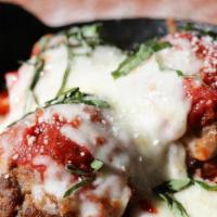 Cast Iron Meatbozz · Baked in a Cast Iron Skillet with Melted Mozzarella and our Pomodoro Sauce, topped with Roma...